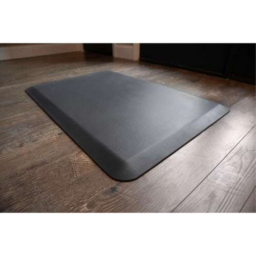 Dark gray EcoLast Premium Standing Mat with beveled edges on a wood floor.